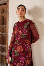 Model in maroon embroidered dress with floral motifs, traditional Pakistani attire with jewelry
